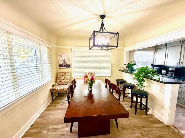 dining area featuring light wood-type flooring and an inviting chandelier