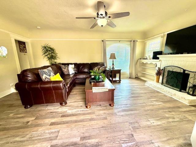 438 E Clinton Ave, Fresno, CA 93704 - living area featuring a ceiling fan, wood finished floors, and a fireplace with raised hearth