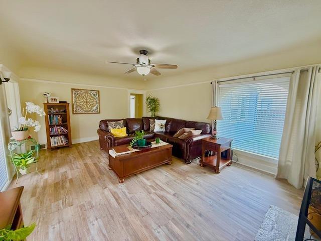 living room featuring light hardwood / wood-style flooring and ceiling fan