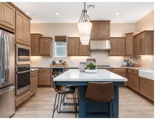 kitchen featuring decorative backsplash, appliances with stainless steel finishes, a breakfast bar area, and a kitchen island