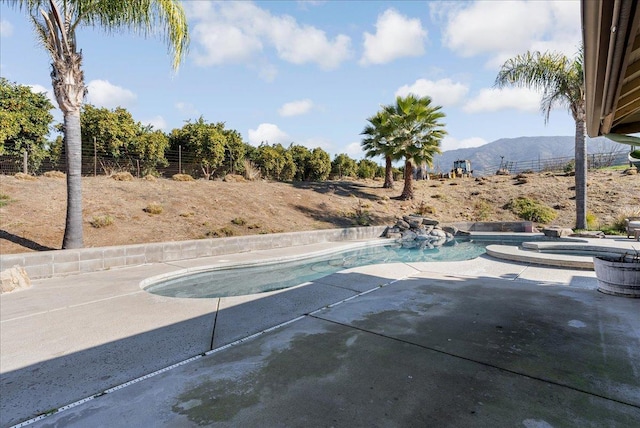 view of swimming pool with an in ground hot tub, a mountain view, and a patio area