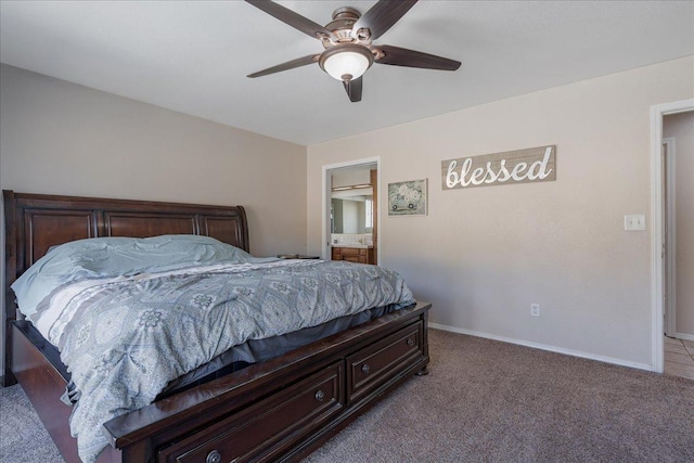 bedroom featuring ensuite bathroom, light colored carpet, and ceiling fan