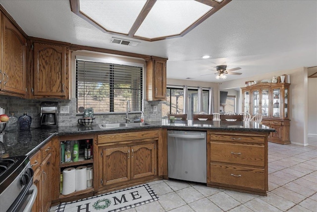 kitchen with appliances with stainless steel finishes, tasteful backsplash, sink, ceiling fan, and kitchen peninsula