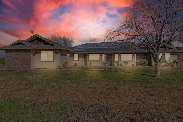 view of front of house with a lawn and solar panels