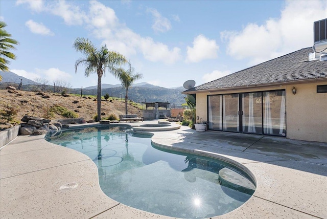 view of swimming pool with an in ground hot tub, a mountain view, and a patio