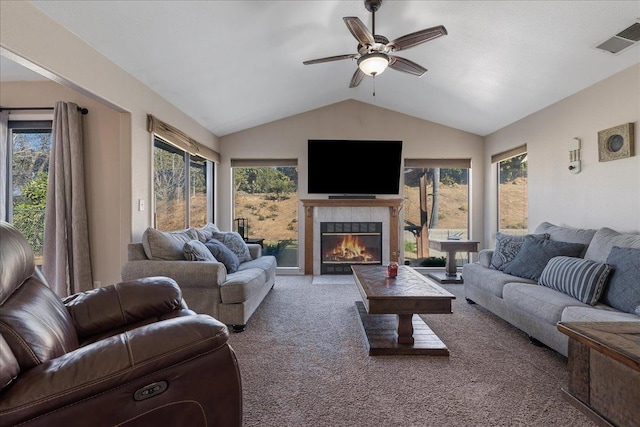 carpeted living room with vaulted ceiling, ceiling fan, and a fireplace