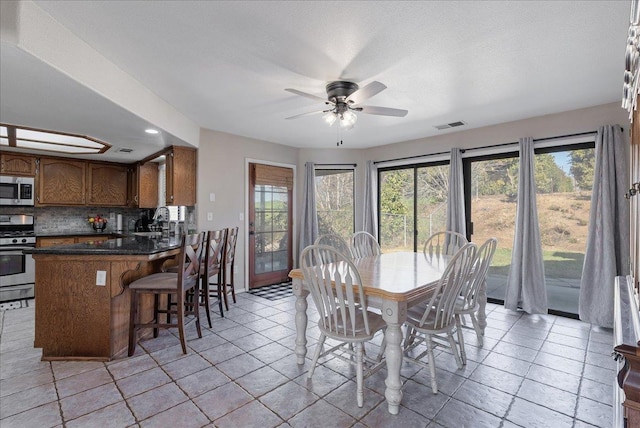 dining room featuring ceiling fan and sink