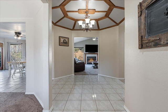 hall with an inviting chandelier, crown molding, and light tile patterned floors