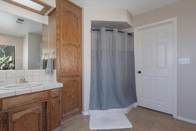 bathroom with tile patterned flooring, vanity, curtained shower, and decorative backsplash