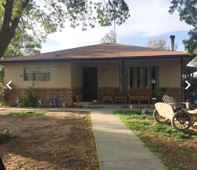 1875 Storey Rd, Madera, CA 93638 - rear view of house featuring an outdoor hangout area, a porch, brick siding, and stucco siding