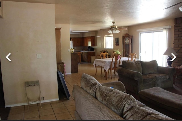 tiled living room featuring a wealth of natural light and ceiling fan