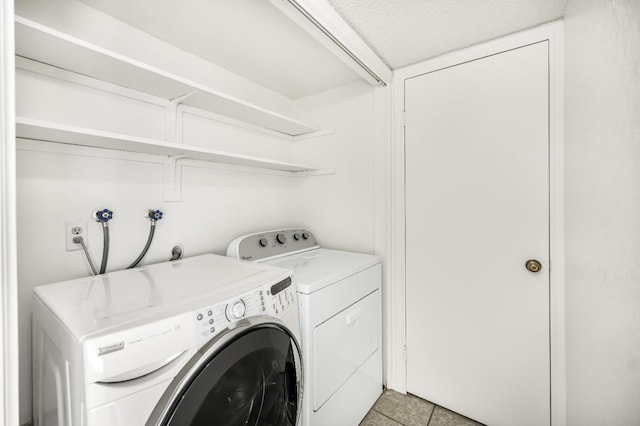 washroom with separate washer and dryer and light tile patterned floors