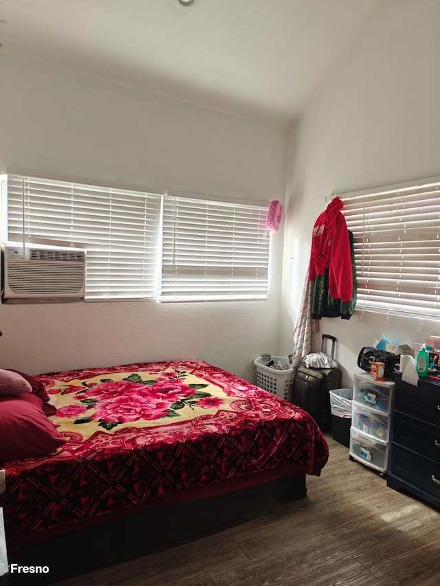 bedroom featuring lofted ceiling, cooling unit, and hardwood / wood-style flooring