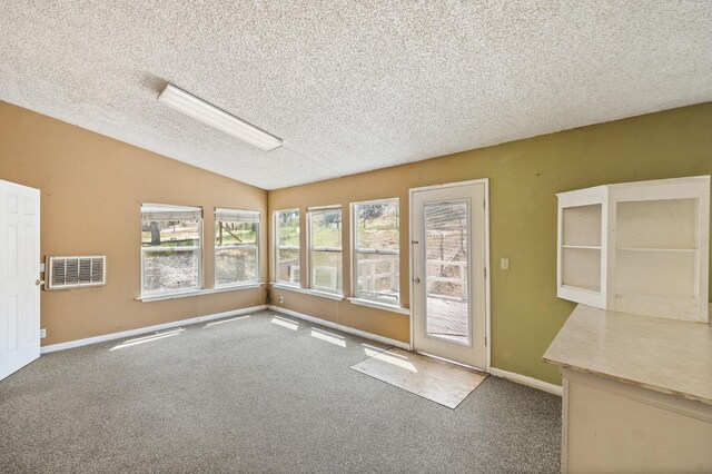 spare room with lofted ceiling, carpet flooring, and a textured ceiling