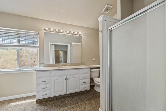 bathroom with vanity, toilet, and a shower with shower door