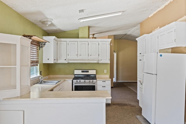 kitchen with sink, white cabinetry, stainless steel range with gas cooktop, kitchen peninsula, and white fridge