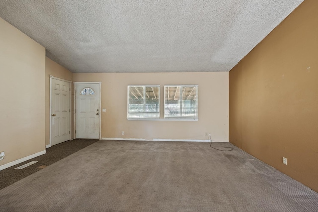 carpeted empty room with vaulted ceiling and a textured ceiling