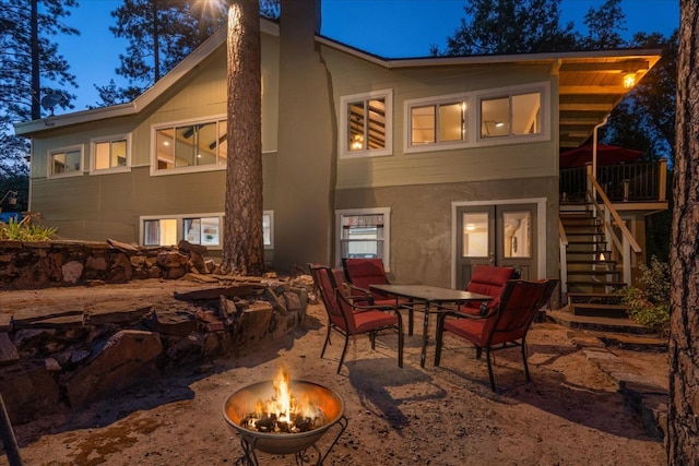 back house at dusk with a patio and a fire pit