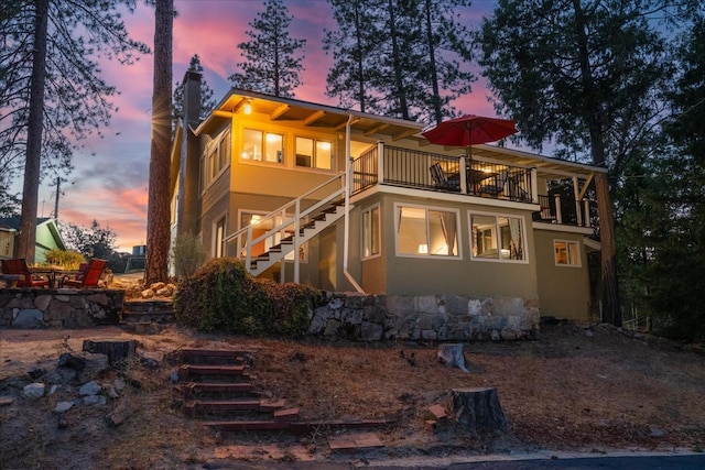 back house at dusk with a balcony