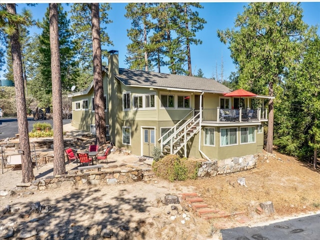 view of front of home featuring a balcony and a fire pit