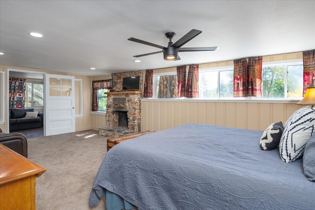 carpeted bedroom featuring multiple windows and a fireplace