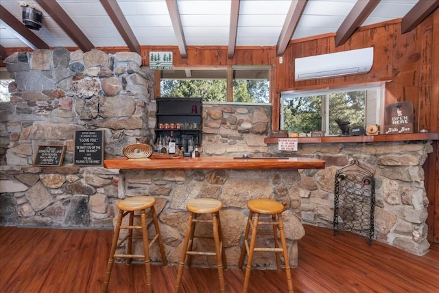 bar with beamed ceiling, hardwood / wood-style floors, a wall unit AC, and wood walls