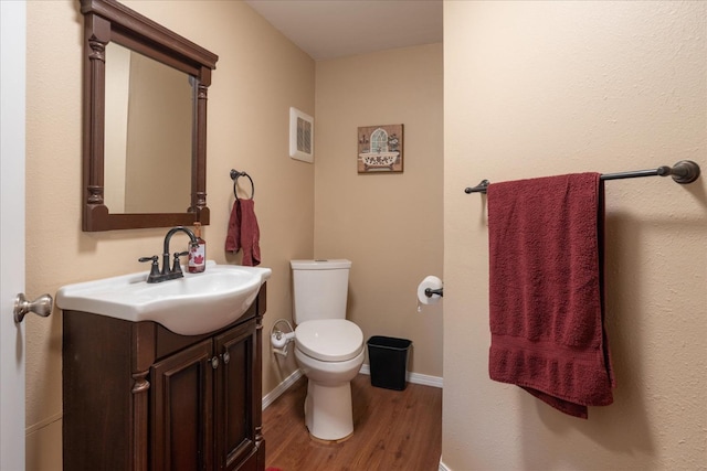 bathroom featuring vanity, hardwood / wood-style flooring, and toilet