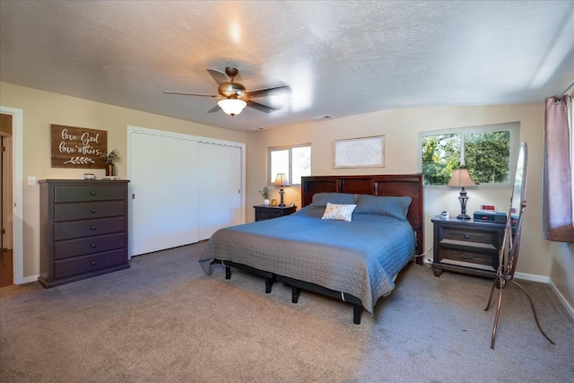 carpeted bedroom featuring ceiling fan, a textured ceiling, and a closet