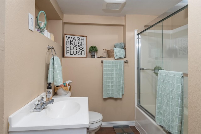 full bathroom with vanity, wood-type flooring, shower / bath combination with glass door, and toilet