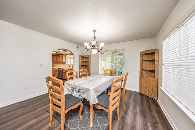 dining room with dark wood-type flooring, sink, and a chandelier