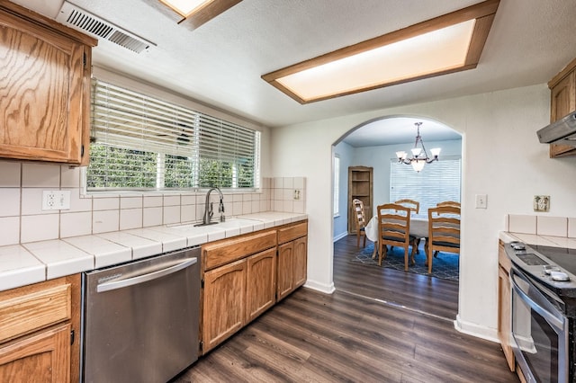 kitchen featuring decorative light fixtures, sink, backsplash, tile counters, and stainless steel appliances