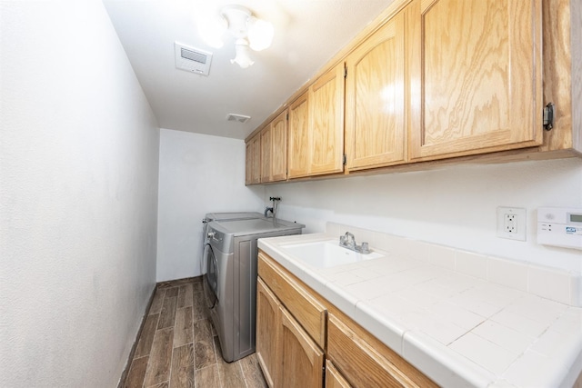 laundry room with cabinets, sink, and washing machine and clothes dryer