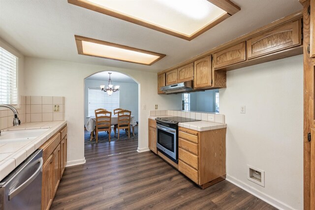 kitchen featuring tile countertops, sink, hanging light fixtures, stainless steel appliances, and dark wood-type flooring