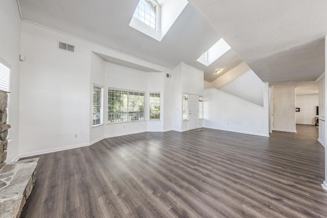 unfurnished living room with dark hardwood / wood-style flooring, a skylight, and high vaulted ceiling