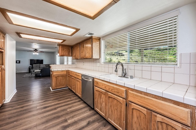 kitchen featuring sink, stainless steel dishwasher, tile counters, dark hardwood / wood-style flooring, and backsplash