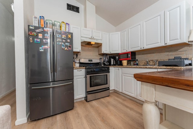 kitchen featuring lofted ceiling, stainless steel appliances, and white cabinets