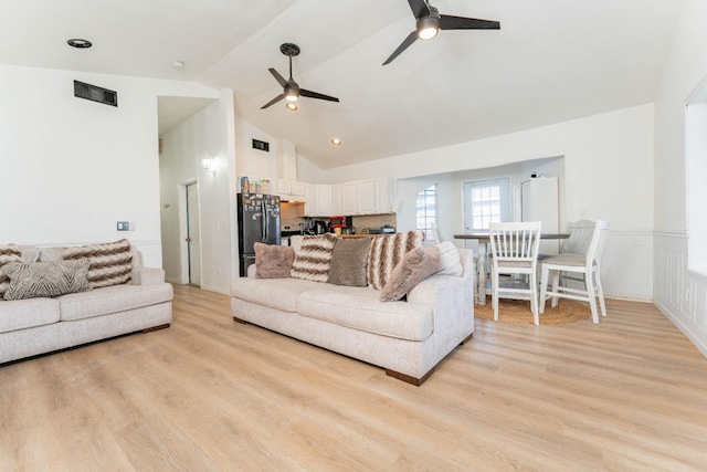 living room featuring high vaulted ceiling, ceiling fan, and light wood-type flooring