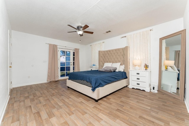 bedroom featuring ceiling fan, light hardwood / wood-style floors, and a textured ceiling