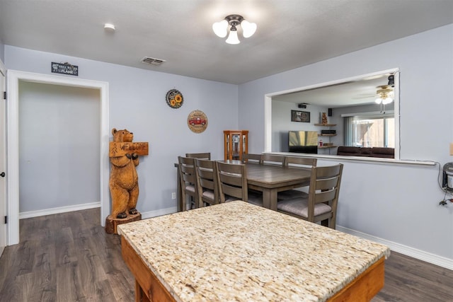 dining space with dark wood-type flooring and ceiling fan