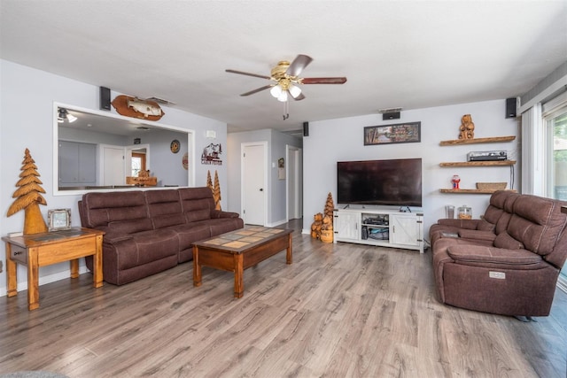 living room with ceiling fan and light wood-type flooring