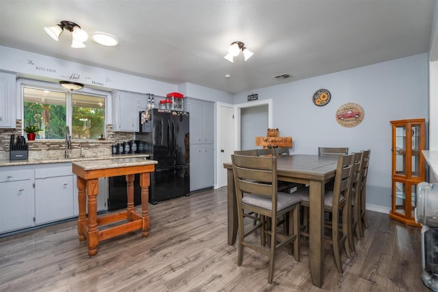 dining area featuring sink and wood-type flooring