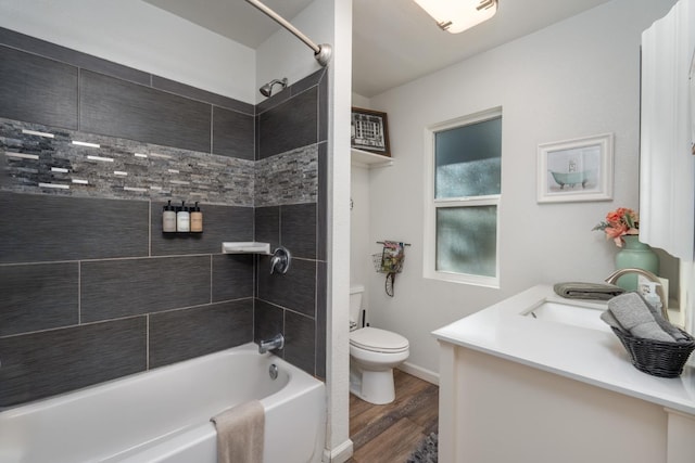 full bathroom featuring vanity, tiled shower / bath, hardwood / wood-style flooring, and toilet