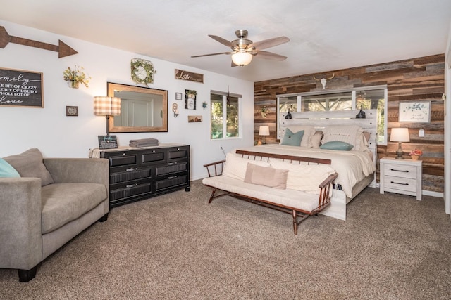 bedroom with ceiling fan, carpet floors, and wooden walls