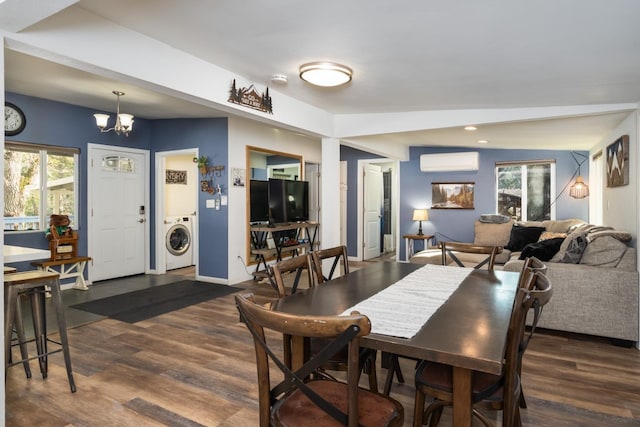 dining space with dark hardwood / wood-style flooring, a wall mounted air conditioner, washer / dryer, and an inviting chandelier