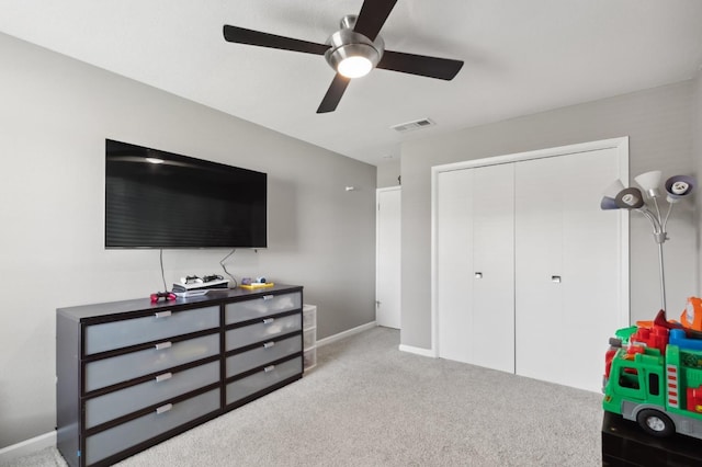 carpeted bedroom featuring a closet and ceiling fan