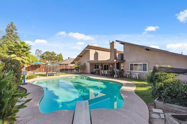 view of swimming pool with a diving board and a patio area