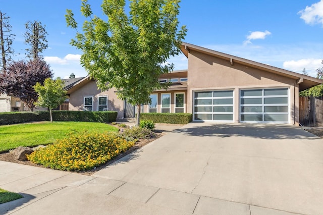 view of front of property featuring a garage and a front lawn