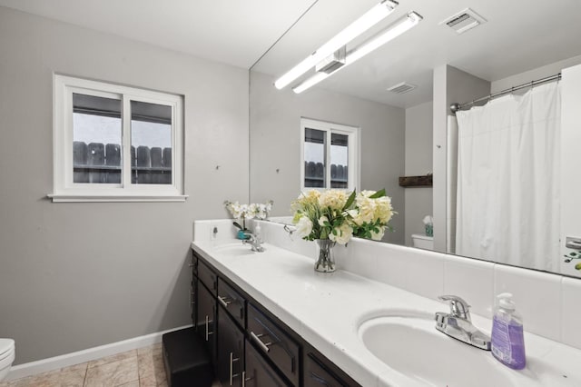 bathroom featuring tile patterned flooring, vanity, and toilet