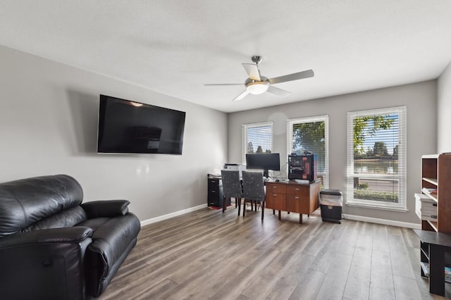 home office featuring wood-type flooring and ceiling fan