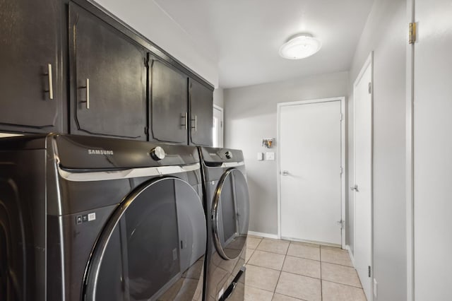 laundry room with light tile patterned floors, washing machine and dryer, and cabinets